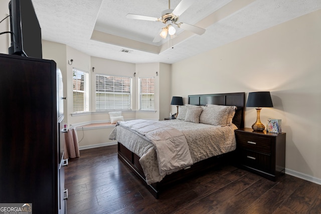 8180 Chapman Ter, Mcdonough, GA 30252 - bedroom featuring a tray ceiling, baseboards, dark wood finished floors, a textured ceiling, and a ceiling fan