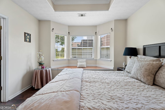 8180 Chapman Ter, Mcdonough, GA 30252 - bedroom with wood finished floors, a raised ceiling, and a textured ceiling