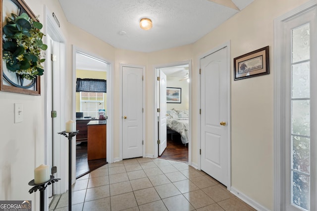 8180 Chapman Ter, Mcdonough, GA 30252 - corridor with light tile patterned floors and a textured ceiling