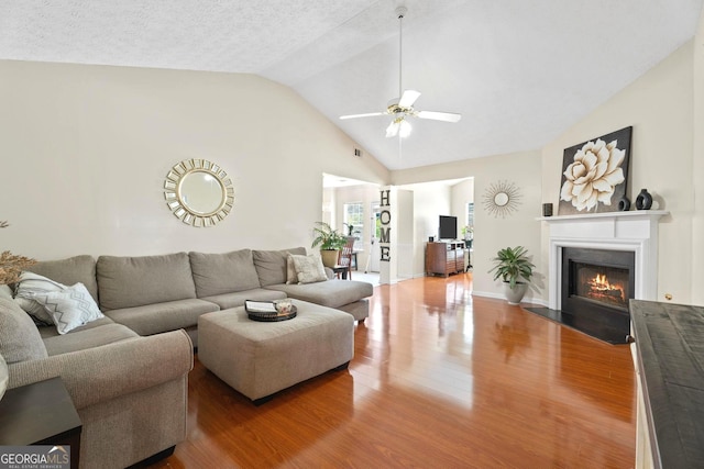 8180 Chapman Ter, Mcdonough, GA 30252 - living area featuring a ceiling fan, lofted ceiling, wood finished floors, and a fireplace with flush hearth