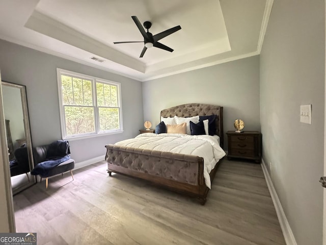 4867 Pinnacle Dr, Stone Mountain, GA 30088 - bedroom featuring a tray ceiling, light wood-type flooring, baseboards, ornamental molding, and a ceiling fan