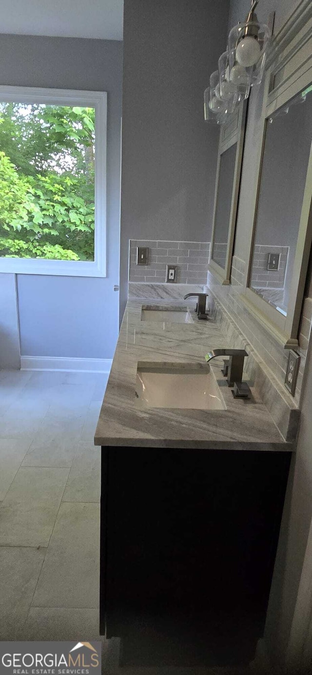4867 Pinnacle Dr, Stone Mountain, GA 30088 - full bath featuring double vanity, tasteful backsplash, baseboards, and a chandelier