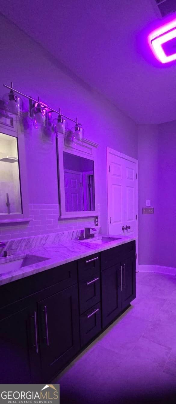 4867 Pinnacle Dr, Stone Mountain, GA 30088 - bathroom with decorative backsplash, double vanity, and baseboards