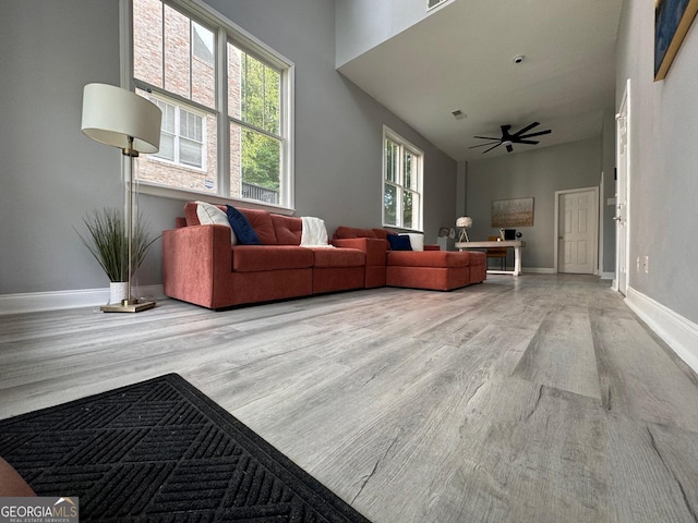 4867 Pinnacle Dr, Stone Mountain, GA 30088 - living room with wood finished floors, baseboards, ceiling fan, and a towering ceiling