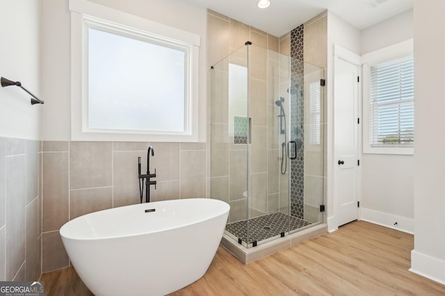 1253 Cumberland Valley Rd, Gainesville, GA 30501 - bathroom featuring a soaking tub, a shower stall, wood finished floors, tile walls, and baseboards