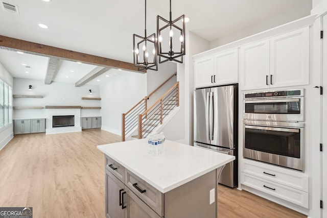 1253 Cumberland Valley Rd, Gainesville, GA 30501 - kitchen with stainless steel appliances, a center island, light wood-style flooring, beamed ceiling, and a chandelier