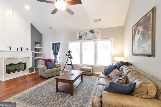 5365 Twin Creeks Dr, Norcross, GA 30071 - living area featuring lofted ceiling, wood finished floors, built in shelves, ceiling fan, and a fireplace