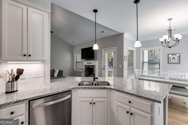 728 Harmony Rd, Temple, GA 30179 - kitchen with dishwasher, a sink, a chandelier, decorative backsplash, and a lit fireplace
