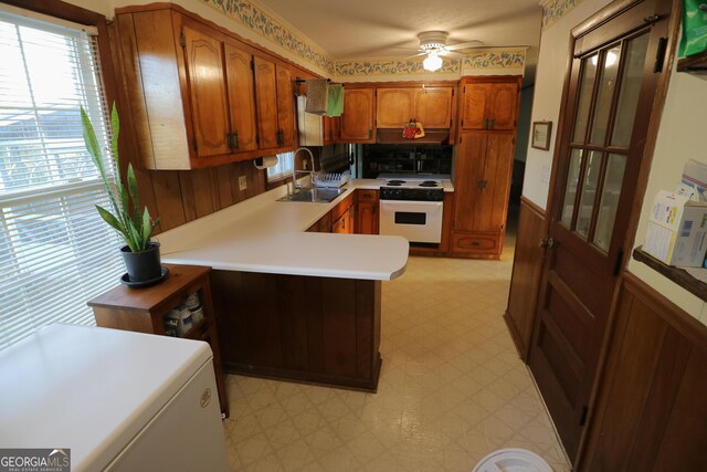 1116 David Newton Rd, Norman Park, GA 31771 - kitchen with a sink, electric range, light flooring, brown cabinetry, and a peninsula