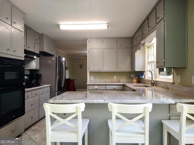 302 Morningside Dr, Clarkesville, GA 30523 - kitchen featuring a sink, a peninsula, black appliances, light stone countertops, and a breakfast bar