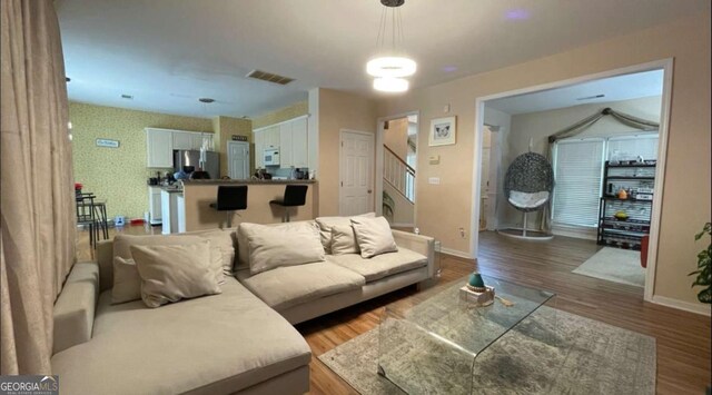 1008 Post Horn Run, Lawrenceville, GA 30045 - living area with wood finished floors, stairs, and wallpapered walls