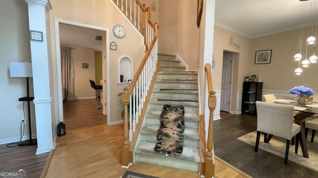 1008 Post Horn Run, Lawrenceville, GA 30045 - staircase featuring wood finished floors, a chandelier, and crown molding