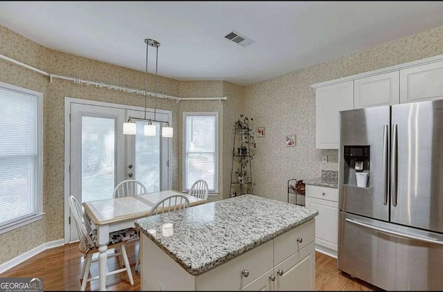 1008 Post Horn Run, Lawrenceville, GA 30045 - kitchen with stainless steel refrigerator with ice dispenser, wood finished floors, wallpapered walls, white cabinetry, and light stone counters
