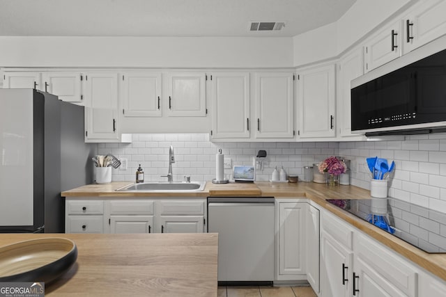107 Rose Dhu Way, Savannah, GA 31419 - kitchen featuring dishwasher, a sink, freestanding refrigerator, white cabinetry, and black electric cooktop