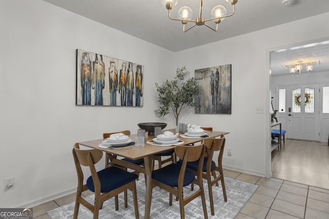 107 Rose Dhu Way, Savannah, GA 31419 - dining space featuring a chandelier, light tile patterned floors, a textured ceiling, and baseboards