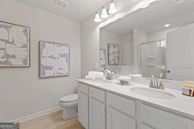 377 Navigator Ln, Mcdonough, GA 30253 - bathroom featuring double vanity, toilet, wood finished floors, an enclosed shower, and baseboards
