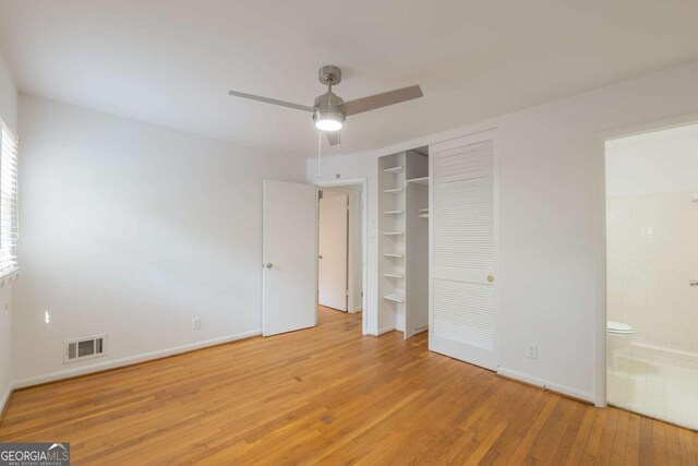 1671 Drayton Woods Dr, Tucker, GA 30084 - unfurnished bedroom with wood finished floors, baseboards, connected bathroom, a closet, and a ceiling fan