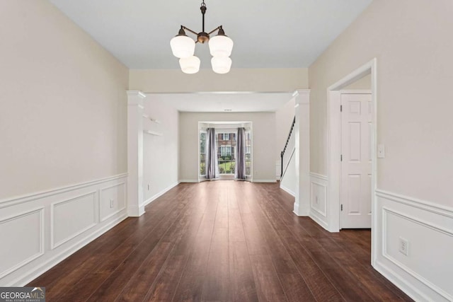 153 Towey Trl, Woodstock, GA 30188 - foyer entrance with stairway, a chandelier, wainscoting, dark wood finished floors, and a decorative wall