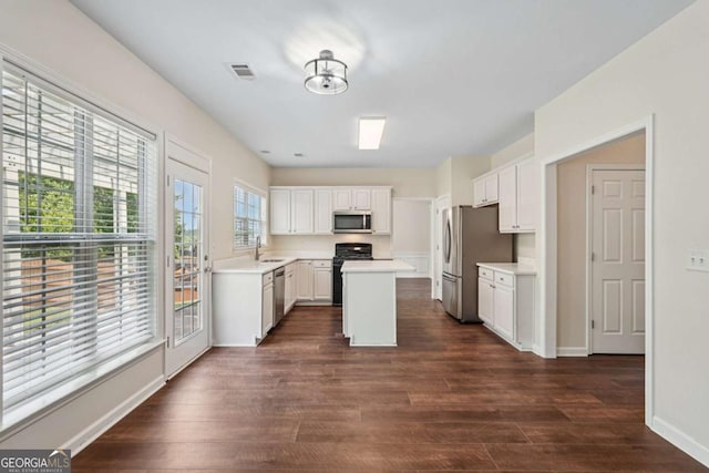 153 Towey Trl, Woodstock, GA 30188 - kitchen with stainless steel appliances, dark wood finished floors, light countertops, a kitchen island, and white cabinets