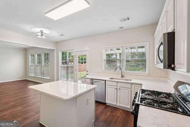 153 Towey Trl, Woodstock, GA 30188 - kitchen with stainless steel appliances, dark wood-style floors, a kitchen island, white cabinetry, and a sink
