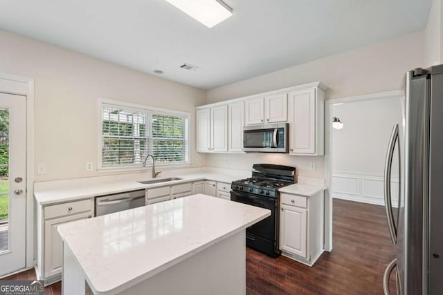 153 Towey Trl, Woodstock, GA 30188 - kitchen featuring stainless steel appliances, a sink, dark wood-style floors, white cabinets, and a center island
