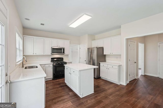 153 Towey Trl, Woodstock, GA 30188 - kitchen featuring appliances with stainless steel finishes, a sink, light countertops, and a kitchen island