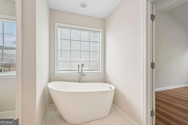 153 Towey Trl, Woodstock, GA 30188 - bathroom with a freestanding bath, baseboards, and plenty of natural light