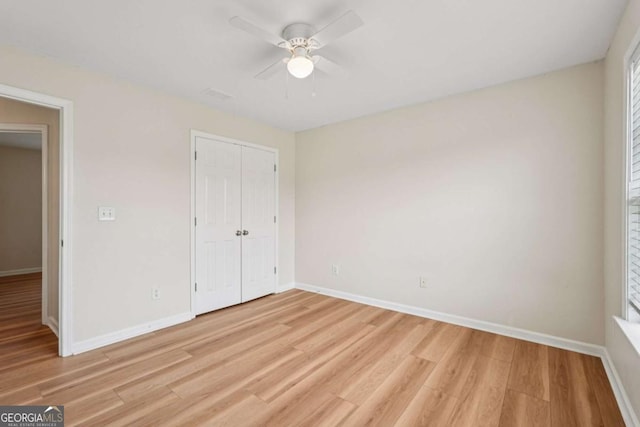 153 Towey Trl, Woodstock, GA 30188 - unfurnished bedroom featuring light wood-type flooring, baseboards, a closet, and ceiling fan