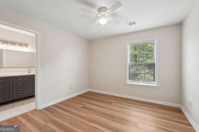 153 Towey Trl, Woodstock, GA 30188 - unfurnished bedroom featuring light wood-type flooring, a sink, baseboards, ensuite bathroom, and ceiling fan