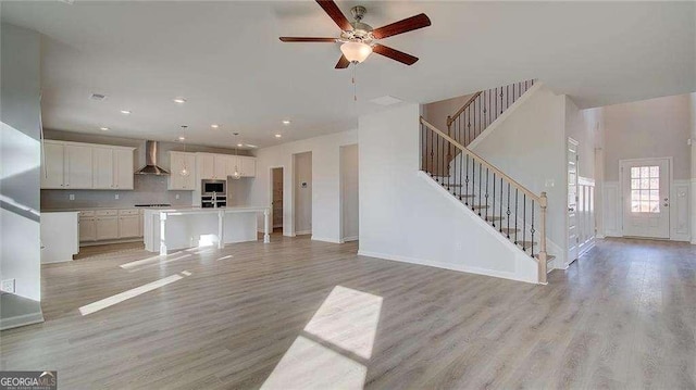 308 Delta Dr, Mcdonough, GA 30253 - unfurnished living room with light wood-type flooring, stairway, ceiling fan, recessed lighting, and baseboards