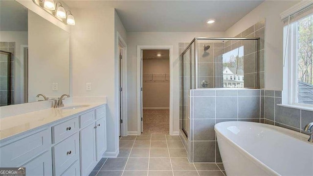308 Delta Dr, Mcdonough, GA 30253 - full bathroom with a freestanding tub, a shower stall, vanity, a spacious closet, and tile patterned flooring