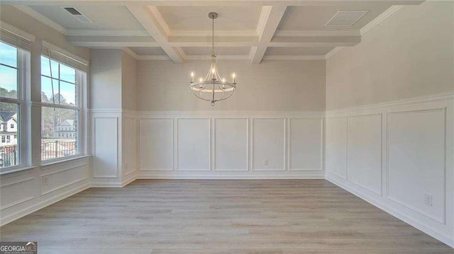 308 Delta Dr, Mcdonough, GA 30253 - unfurnished dining area featuring a decorative wall, a chandelier, beam ceiling, coffered ceiling, and light wood-type flooring