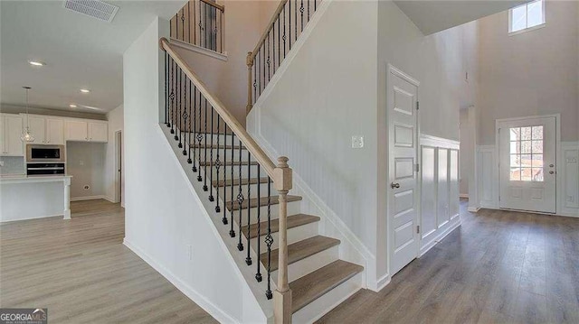 308 Delta Dr, Mcdonough, GA 30253 - staircase with a high ceiling, wood finished floors, healthy amount of natural light, and recessed lighting