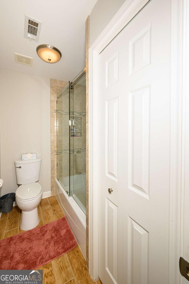 1409 Echo Mill Dr, Powder Springs, GA 30127 - bathroom with toilet, bath / shower combo with glass door, and baseboards