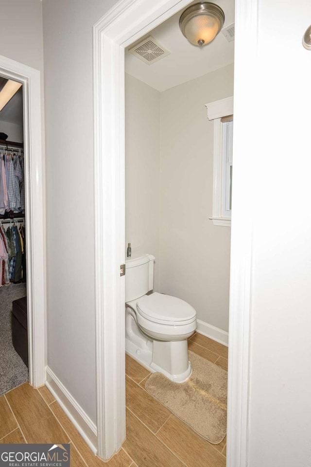 1409 Echo Mill Dr, Powder Springs, GA 30127 - bathroom with wood finish floors, toilet, baseboards, and a walk in closet