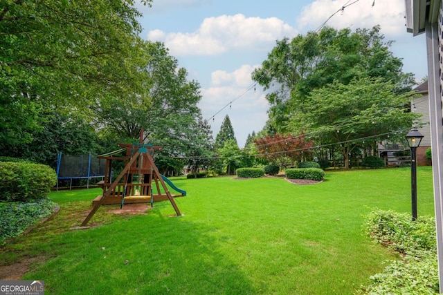 1409 Echo Mill Dr, Powder Springs, GA 30127 - view of green lawn with a trampoline and a playground