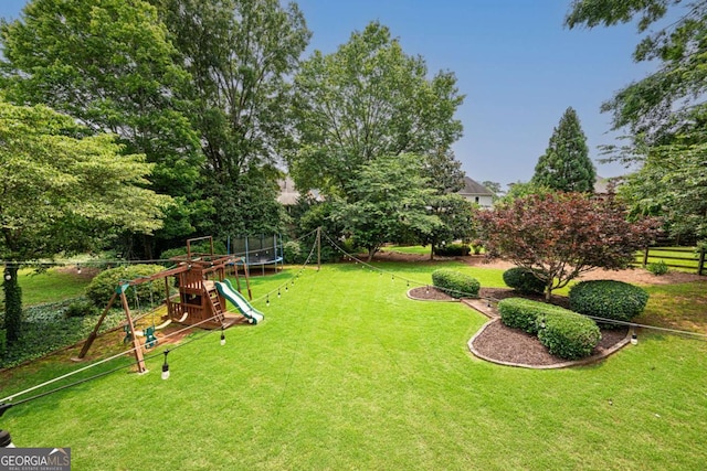 1409 Echo Mill Dr, Powder Springs, GA 30127 - view of grassy yard featuring a trampoline and a playground