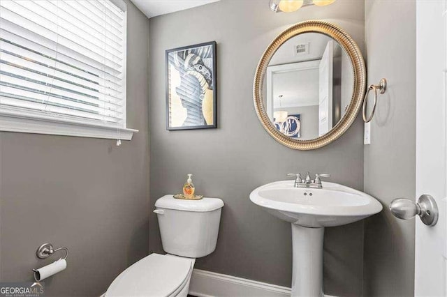 5880 Garden Cir, Douglasville, GA 30135 - half bathroom with toilet, healthy amount of natural light, baseboards, and a sink