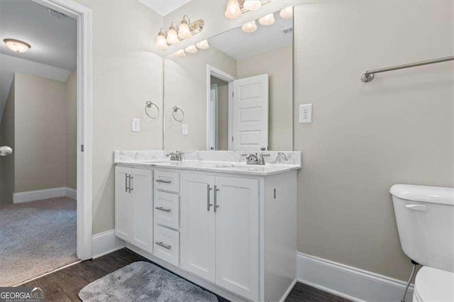 5880 Garden Cir, Douglasville, GA 30135 - full bath featuring toilet, double vanity, baseboards, and wood finished floors