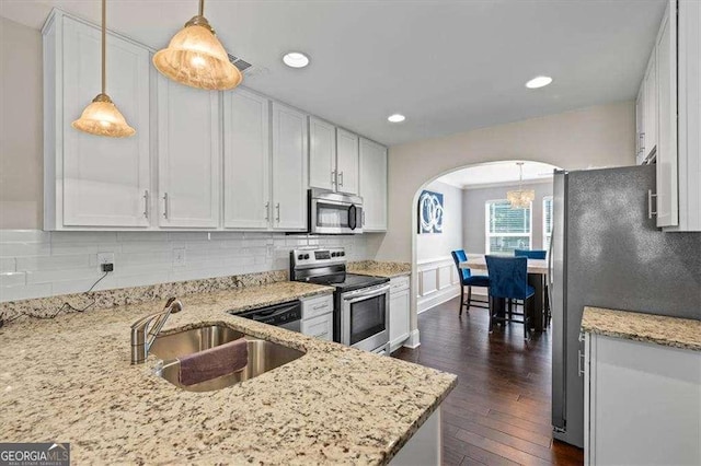5880 Garden Cir, Douglasville, GA 30135 - kitchen featuring appliances with stainless steel finishes, a sink, arched walkways, dark wood finished floors, and light stone countertops