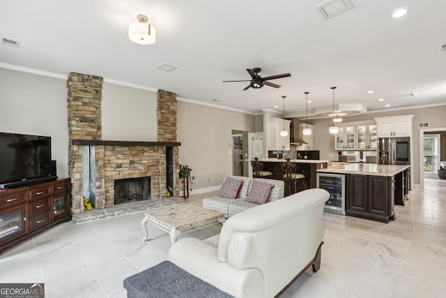 511 Pine Valley Rd SE, Marietta, GA 30067 - living area featuring wine cooler, crown molding, a ceiling fan, a stone fireplace, and recessed lighting
