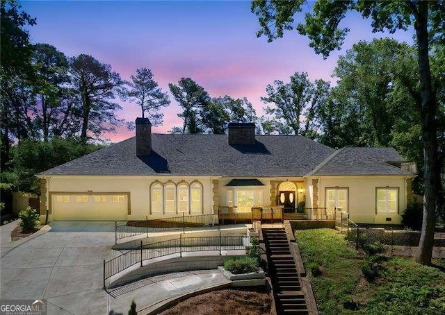 511 Pine Valley Rd SE, Marietta, GA 30067 - view of front facade featuring a chimney, concrete driveway, a garage, stairs, and stucco siding