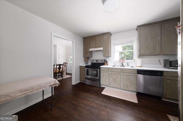 2820 Channing Way, Cumming, GA 30040 - kitchen with appliances with stainless steel finishes, a sink, dark wood-style flooring, light countertops, and under cabinet range hood