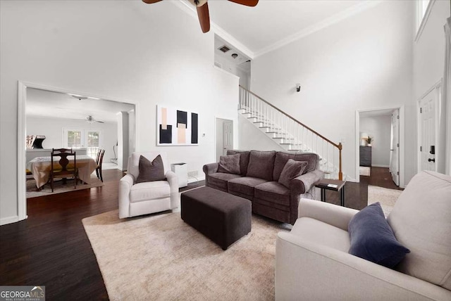 2820 Channing Way, Cumming, GA 30040 - living room featuring ceiling fan, a towering ceiling, stairs, wood finished floors, and crown molding