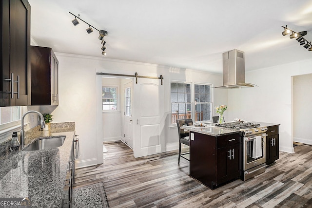 2674 Skylane Dr, Marietta, GA 30062 - kitchen with high end stainless steel range oven, island range hood, track lighting, a barn door, and wood finished floors
