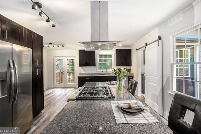 2674 Skylane Dr, Marietta, GA 30062 - kitchen featuring stainless steel fridge with ice dispenser, island range hood, a barn door, rail lighting, and dark brown cabinets