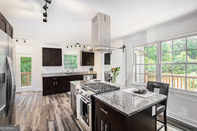 2674 Skylane Dr, Marietta, GA 30062 - kitchen with appliances with stainless steel finishes, island range hood, rail lighting, wood finished floors, and a kitchen island