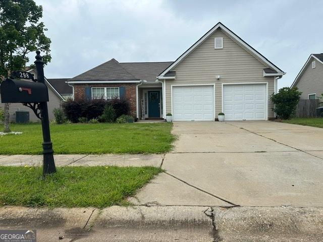 298 Timberwind Dr, Byron, GA 31008 - view of front of house featuring an attached garage, driveway, a front lawn, and brick siding