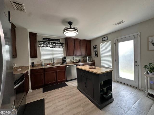 298 Timberwind Dr, Byron, GA 31008 - kitchen featuring dishwasher, electric range oven, a sink, light countertops, and a kitchen island
