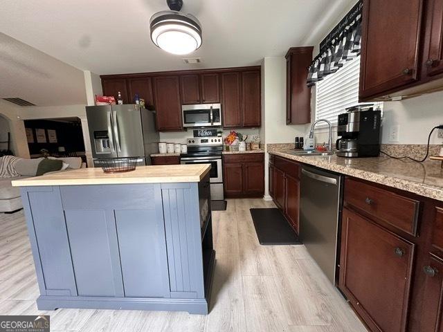 298 Timberwind Dr, Byron, GA 31008 - kitchen with appliances with stainless steel finishes, a sink, a center island, light wood-type flooring, and open floor plan